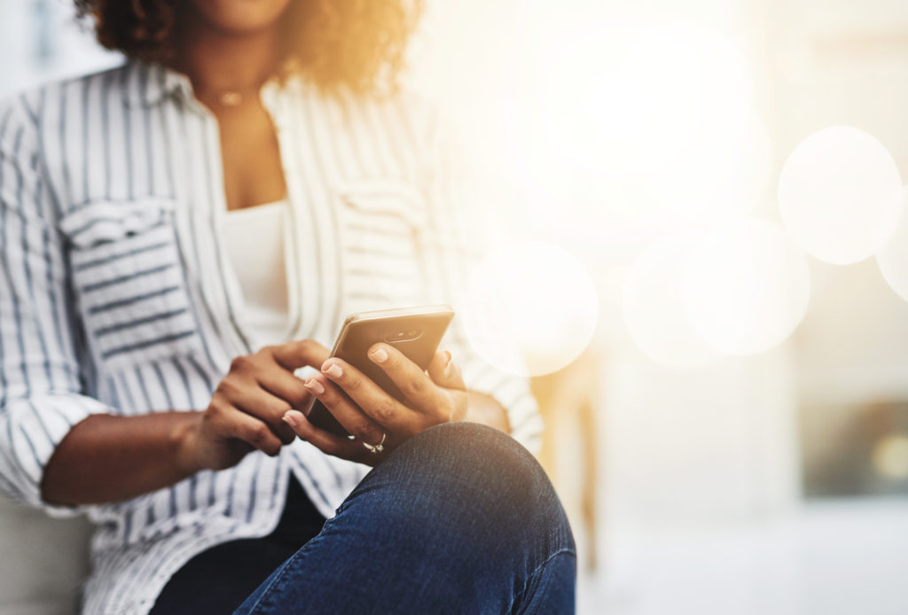 woman in striped shirt checking phone 